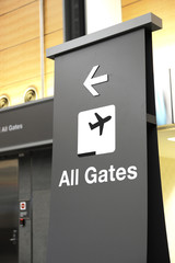 directional sign indicating airport gates for boarding
