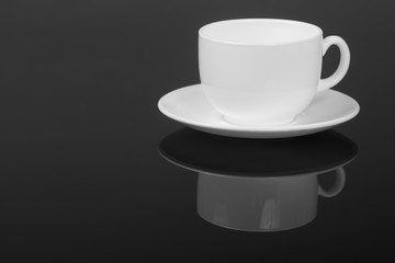 White cup on glossy black background