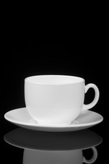White cup on glossy black background