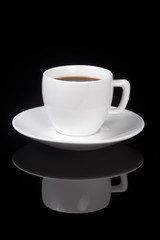 White cup on glossy black background