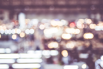 Blurred background: crowd of people in expo fair with bokeh ligh