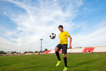 Asian teenager boy in the sports form in a football stadium, pra
