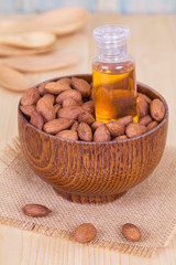 almond oil and  almonds seed on wooden background