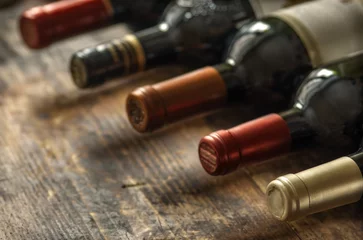  Rij van wijnflessen met droge rode wijn op houten achtergrond. Lage scherptediepte. Wijnbereiding en wijnwinkelconcept. © aleks-p