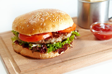 Hamburger and french fries in a mug on white background