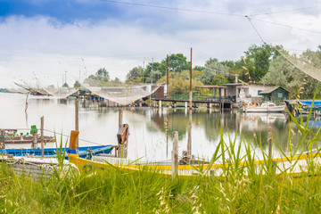 ships and fishing huts in the quiet of brackish lagoon