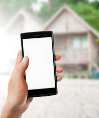 Hand holding smart phone on tropical hotel resort background.