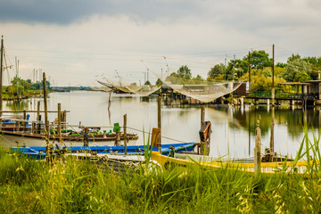 Fototapeta na wymiar ships and fishing huts in the quiet of brackish lagoon