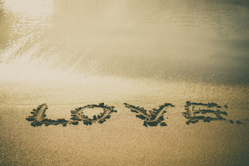 Love text wrote on beach sand