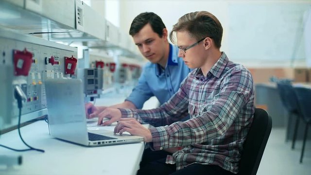 Portrait of a two handsome men using laptop in laboratory