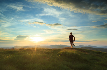 Athlete trailrunning in the mountains during a nice sunset. With shallow D.O.F. and motion blur. - obrazy, fototapety, plakaty