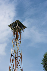 Loudspeakers broadcast tower with a blue sky background 