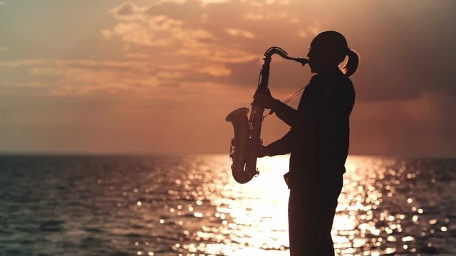 Man playing the saxophone at sunset