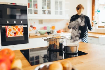 Photo sur Plexiglas Cuisinier Femme au foyer faisant le déjeuner dans la cuisine