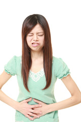young Japanese woman wearing a green summer dress suffers from stomachache