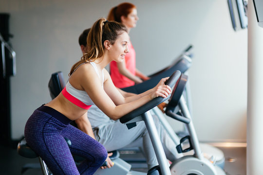 People traning in gym on various machines