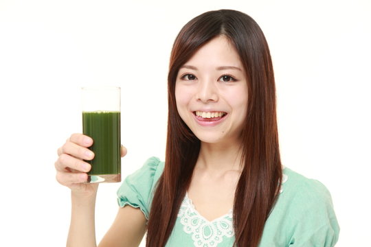 young Japanese woman wearing a green summer dress with green vegetable juice