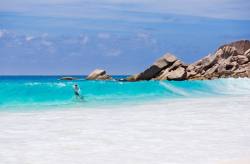 Fototapeta na wymiar Couple enjoy the blue water of the sea in Seychelles