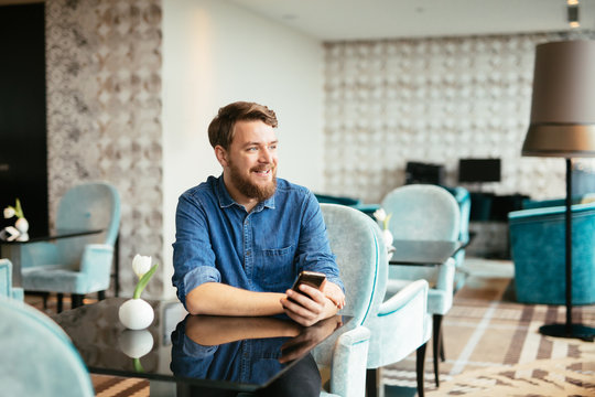 Handsome Man Using Phone In Restaurant