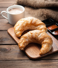 fresh croissants with jam for breakfast on wood