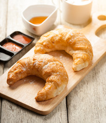 fresh croissants with jam for breakfast on wood