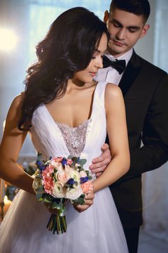 Bride and groom - wedding elegant photo. Bride in a luxury white wedding dress holding bouquet