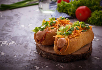 Hot dog with sausage, carrot, onion, lettuce