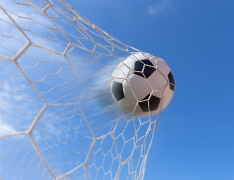 soccer ball in goal with blue sky