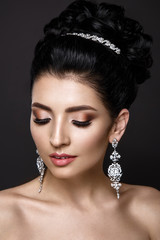 Woman portrait isolated on grey background. Young lady posing with wedding accessories. Gorgeous make up, beautiful hairstyle. 