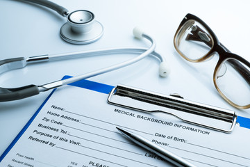 Patient information with pen glasses and stethoscope white backg