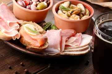 Tapas of salmon, mussels, jamon and olives with beer