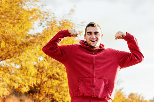 Young handsome man flexing mucles outdoor