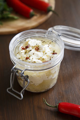 Preserved feta cheese in olive oil with chili and herbs