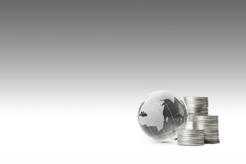 globe and silver coins on gray background