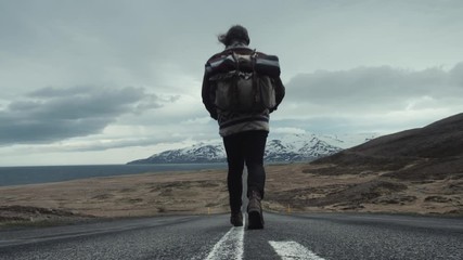 Marcheur sur une route en Islande