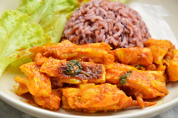 spicy stir fried salmon in curry paste and brown rice on dish