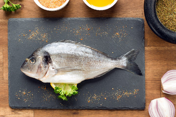 fresh raw dorado fish with spices on white background, top view, square image