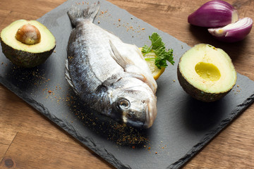 fresh raw dorado fish with spices on white background, top view, square image