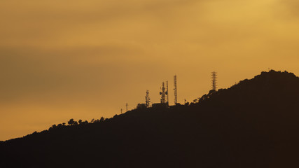Sunset over mountains with communication towers
