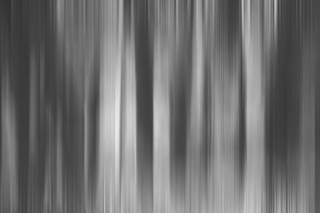 Abstract art for background use. An image of a forest processed with a motion blur effect. The color tone is black and white.