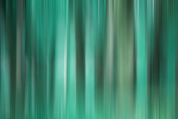 Abstract art for background use. An image of a forest processed with a motion blur effect. The color tone is turquoise.