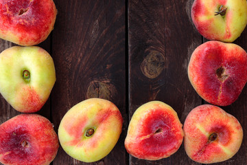 Fresh wet donut saturn peaches on rustic wooden background, center copy space