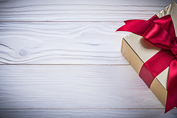 Fototapeta premium Gift-container with tied bow on wooden board holidays concept