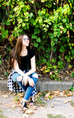 Young girl in hipster outfit sitting in the park - 113681704
