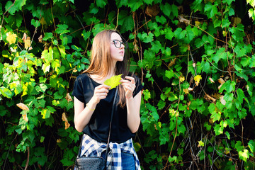 Young beautiful hipster female holding green leaf and standing in the park - 113681714