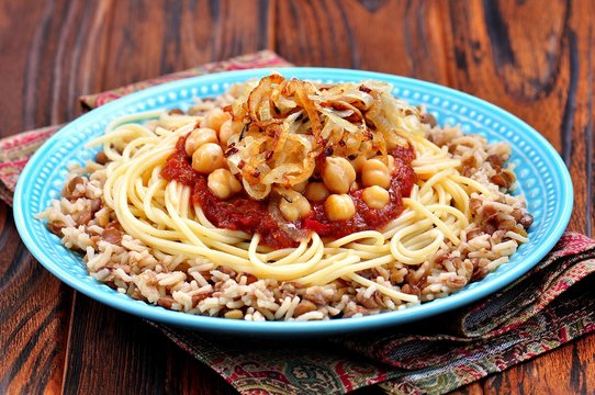 Kushari - Egyptian dish of lentils, rice, pasta, chickpeas with tomato sauce and crispy onions