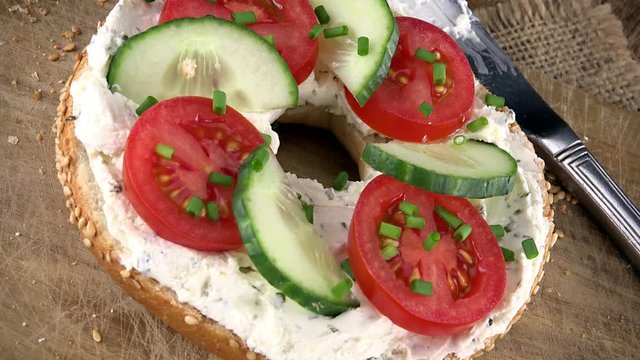 Bagels with Cream Cheese and vegetables (rotating, close-up) as seamless loopable 4K UHD footage