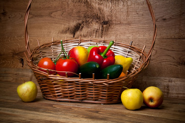 Basket of vegetables and fruits, wooden background