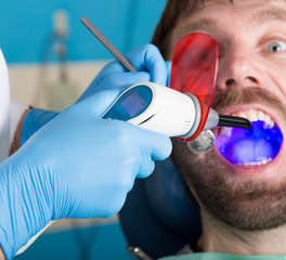 Doctor examines the oral cavity on tooth decay. Caries protection. Tooth decay treatment. Dentist...