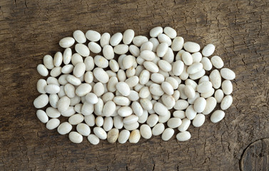 Fototapeta na wymiar Organic navy beans on an old wood board.